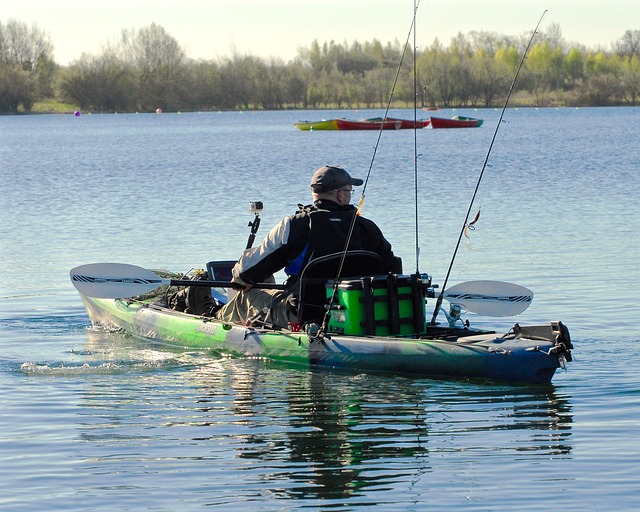 man fishing on green kayak